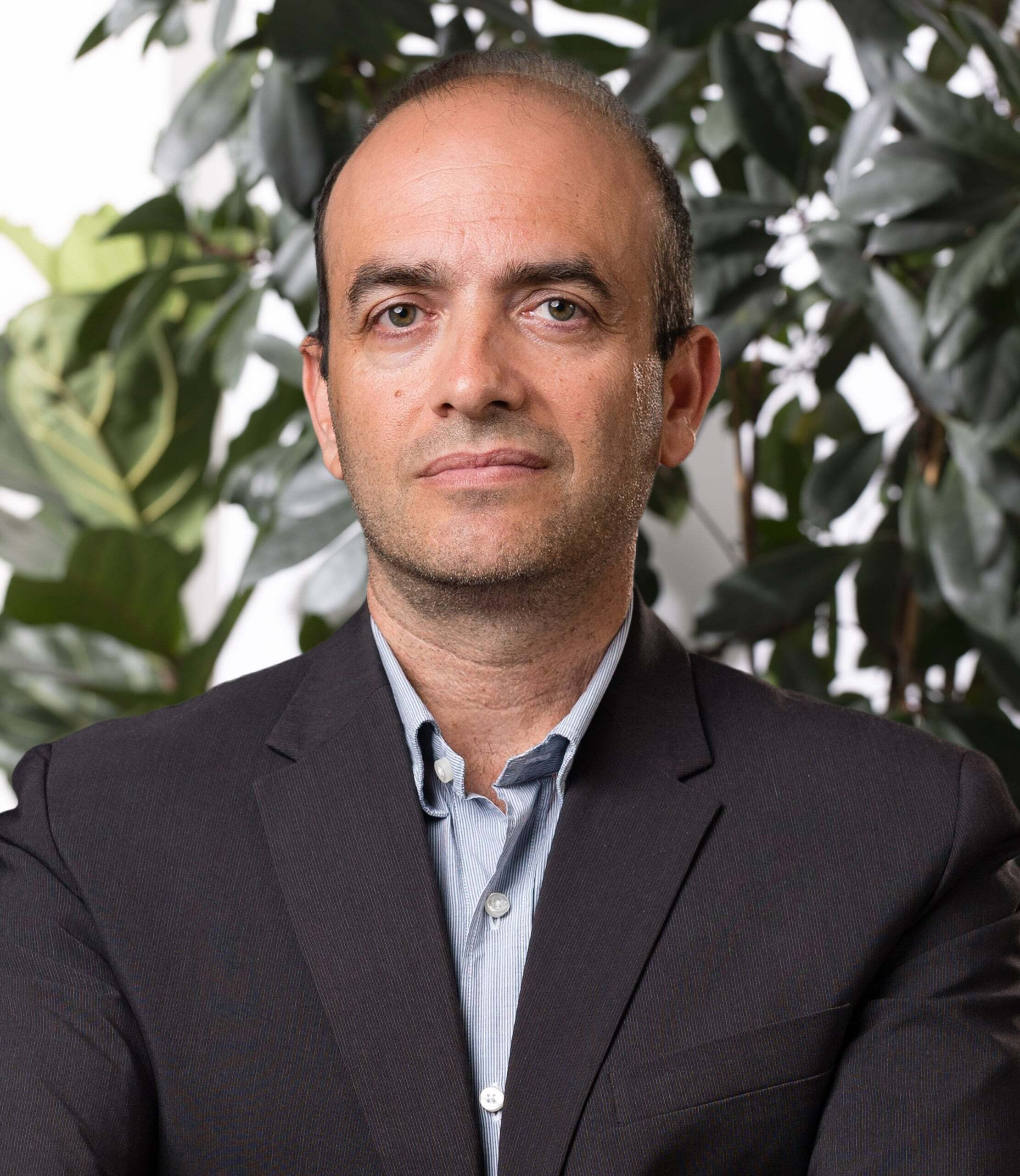 Portrait of a man with glasses wearing a gray shirt.