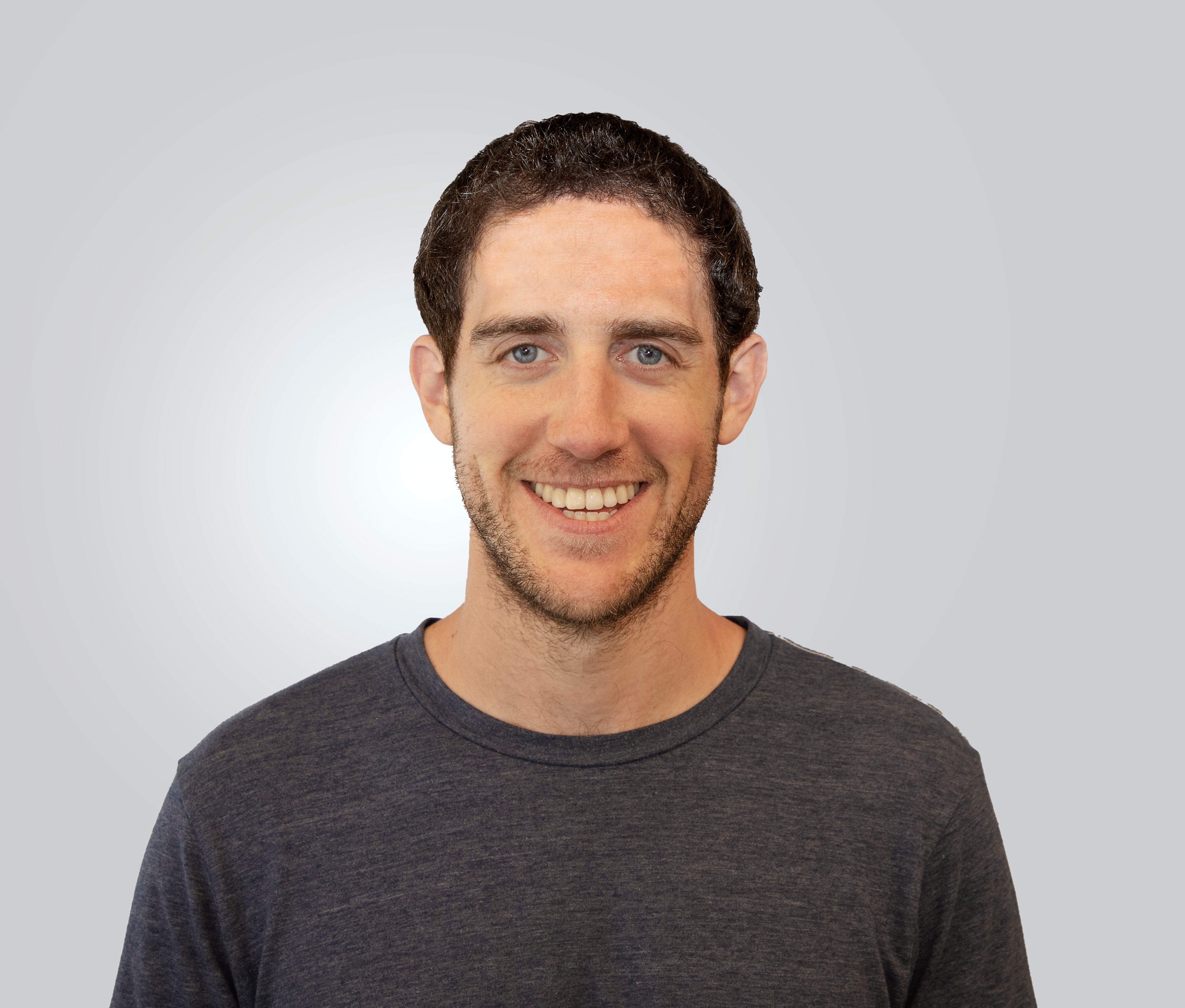 Portrait of a man with glasses wearing a gray shirt.